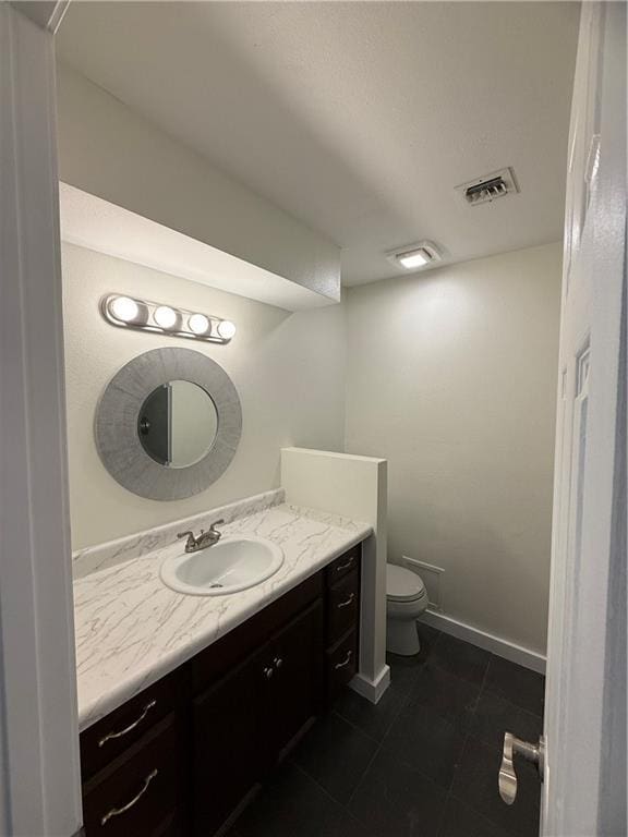 bathroom with tile patterned flooring, vanity, and toilet