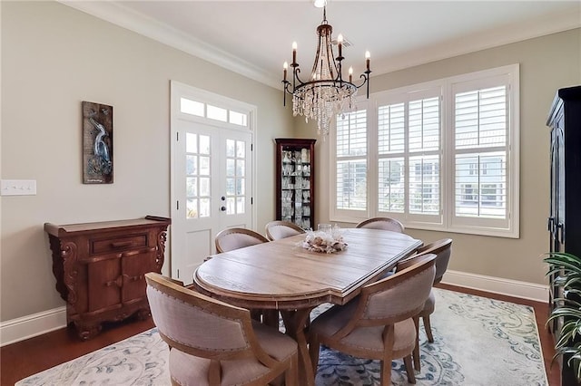 dining space featuring french doors, ornamental molding, a healthy amount of sunlight, and dark hardwood / wood-style flooring