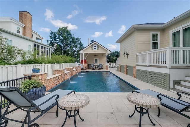 view of pool with pool water feature, an outdoor structure, and a patio area