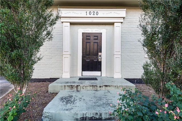 view of exterior entry featuring brick siding