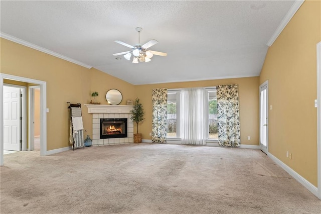 unfurnished living room featuring a tile fireplace, vaulted ceiling, ornamental molding, and light carpet