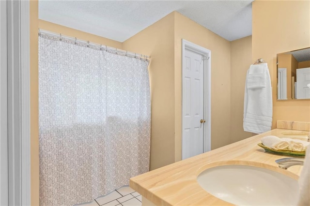 bathroom with vanity, tile patterned flooring, and a textured ceiling