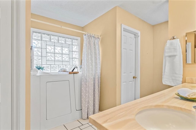 bathroom with vanity, washer / dryer, tile patterned floors, and a textured ceiling