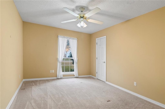 carpeted spare room featuring a textured ceiling and ceiling fan