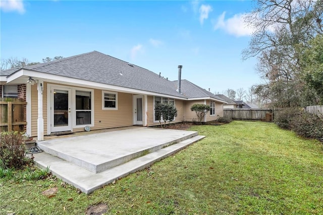 back of property with a yard and a patio