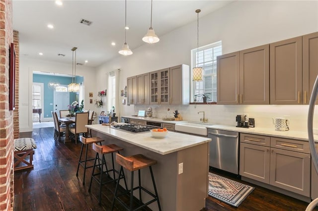 kitchen featuring a kitchen island, appliances with stainless steel finishes, a breakfast bar, and pendant lighting