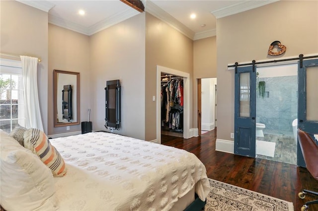 bedroom with dark hardwood / wood-style floors, ornamental molding, a barn door, and a high ceiling