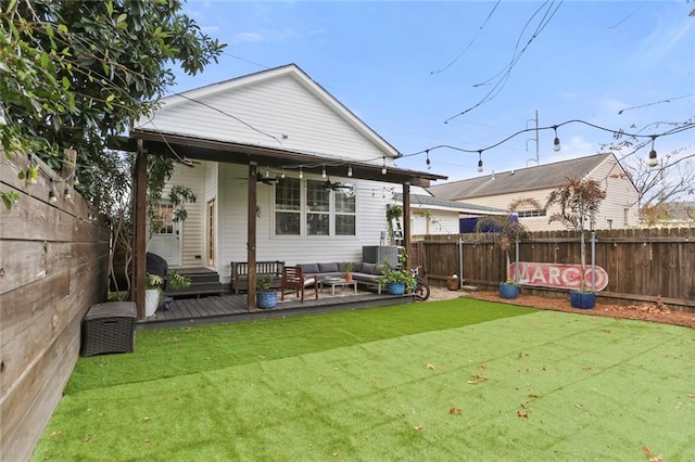 rear view of house with a wooden deck, outdoor lounge area, and a yard