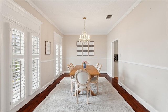 dining space featuring ornamental molding, dark hardwood / wood-style floors, and a notable chandelier