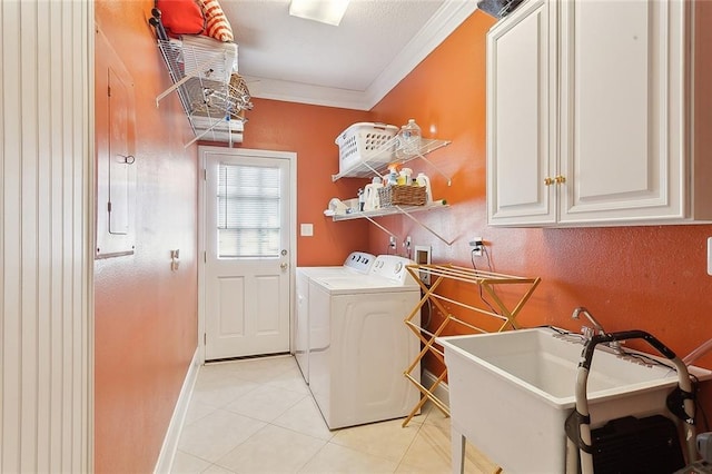 laundry area with sink, cabinets, ornamental molding, light tile patterned floors, and washer and clothes dryer