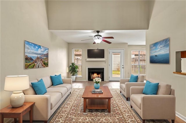 living room featuring ceiling fan and a towering ceiling