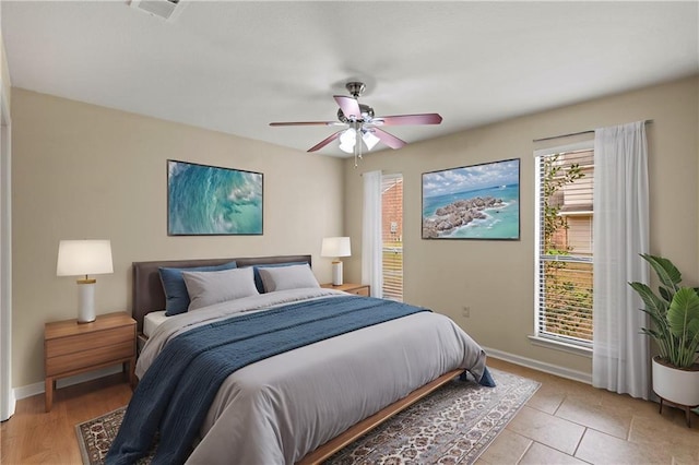 tiled bedroom featuring ceiling fan