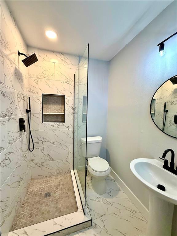 532 Gardere Ave, Harvey, LA 70058 - bathroom featuring marble finish floor, baseboards, a marble finish shower, and toilet
