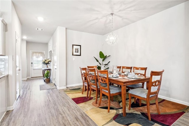 dining area featuring a chandelier and light hardwood / wood-style flooring