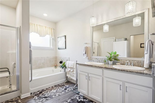 bathroom featuring vanity, plus walk in shower, and wood-type flooring