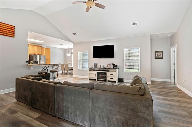 living room with dark wood-type flooring, ceiling fan, and high vaulted ceiling