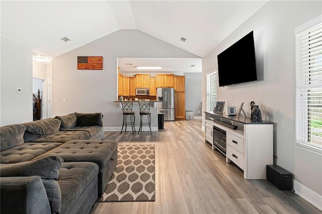 living room with lofted ceiling and light wood-type flooring