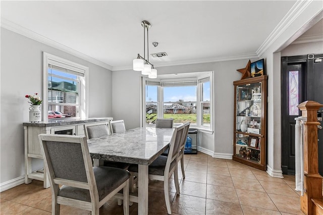 tiled dining room featuring crown molding