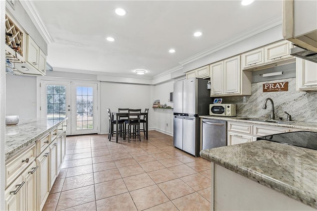 kitchen with crown molding, appliances with stainless steel finishes, and light stone countertops