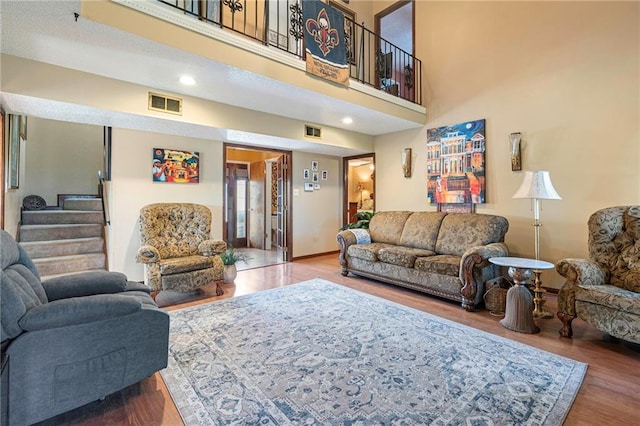 living room with a towering ceiling and hardwood / wood-style floors