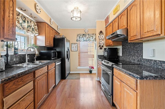 kitchen featuring backsplash, stainless steel appliances, sink, and dark stone countertops