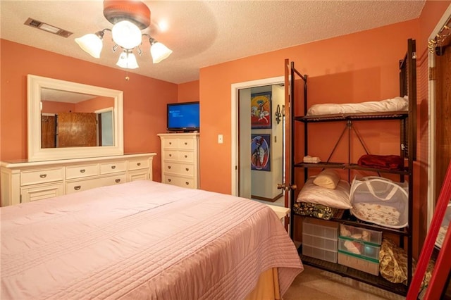 bedroom with ceiling fan and a textured ceiling