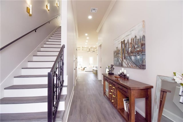 stairs with wood-type flooring and ornamental molding