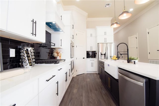 kitchen featuring white cabinetry, sink, hanging light fixtures, stainless steel appliances, and crown molding