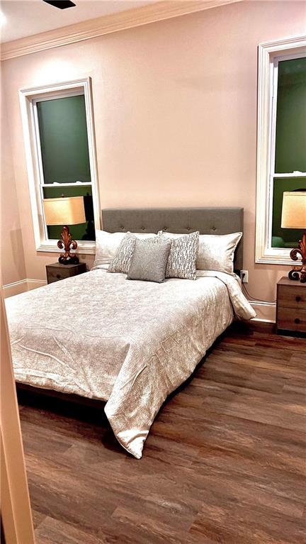 bedroom featuring dark wood-type flooring and crown molding