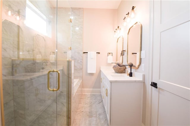 bathroom featuring a shower with door and vanity