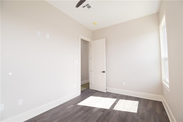 empty room featuring dark hardwood / wood-style flooring and ceiling fan