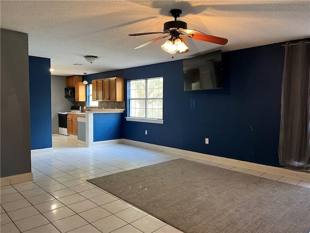 interior space featuring decorative backsplash, light tile patterned floors, ceiling fan, kitchen peninsula, and electric stove