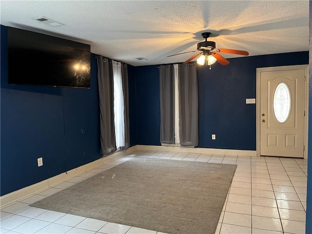 entrance foyer with light tile patterned flooring, ceiling fan, and a textured ceiling