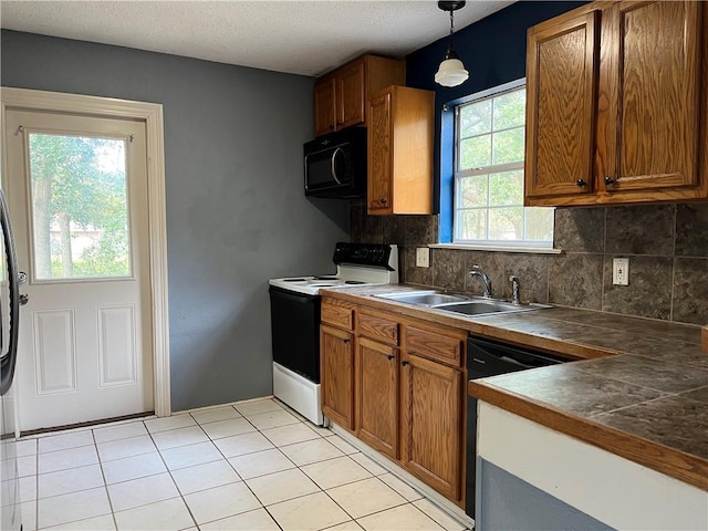 kitchen with pendant lighting, sink, backsplash, and black appliances