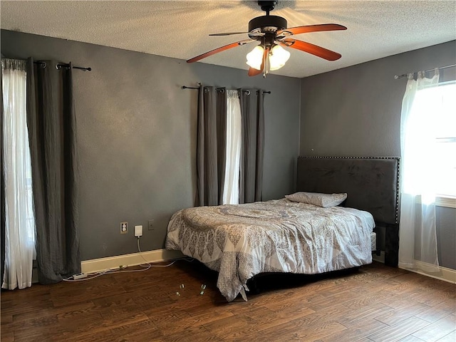 bedroom featuring ceiling fan, hardwood / wood-style flooring, and a textured ceiling