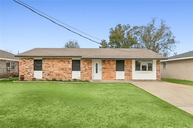 ranch-style home featuring driveway, brick siding, roof with shingles, and a front yard