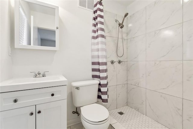 bathroom with a tile shower, visible vents, toilet, and vanity