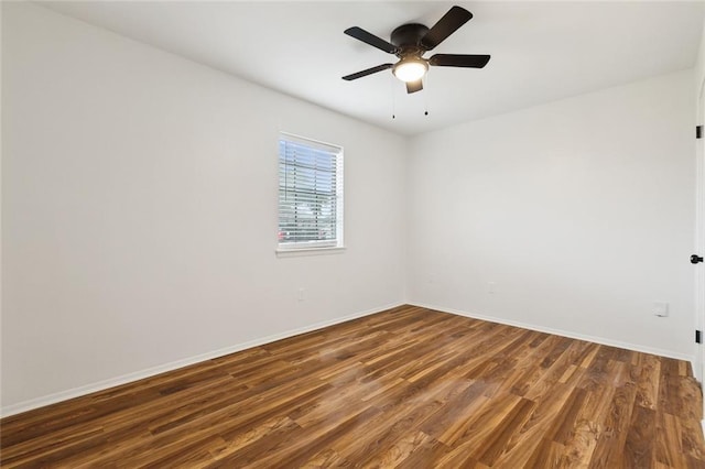 empty room featuring baseboards, wood finished floors, and ceiling fan