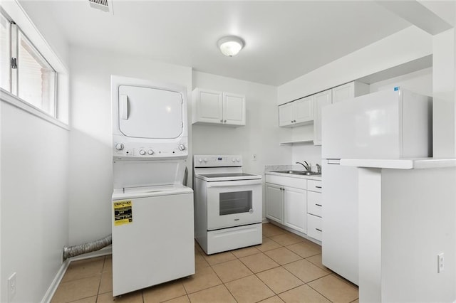 interior space featuring light tile patterned flooring, sink, white cabinetry, white appliances, and stacked washer / dryer