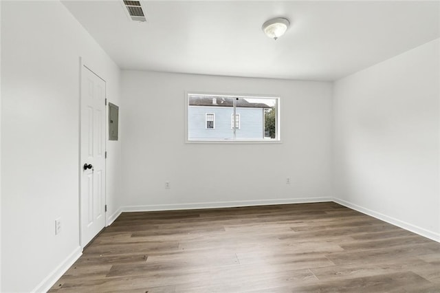 unfurnished room with wood-type flooring and electric panel