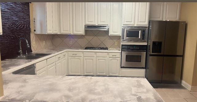 kitchen featuring tasteful backsplash, white cabinetry, stainless steel appliances, and sink