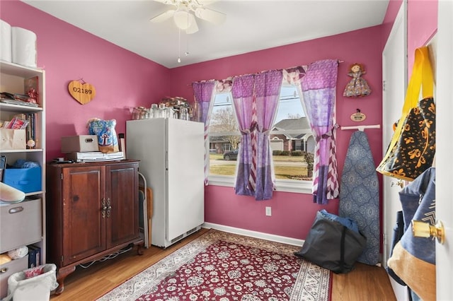 bedroom featuring white fridge, ceiling fan, and light hardwood / wood-style flooring