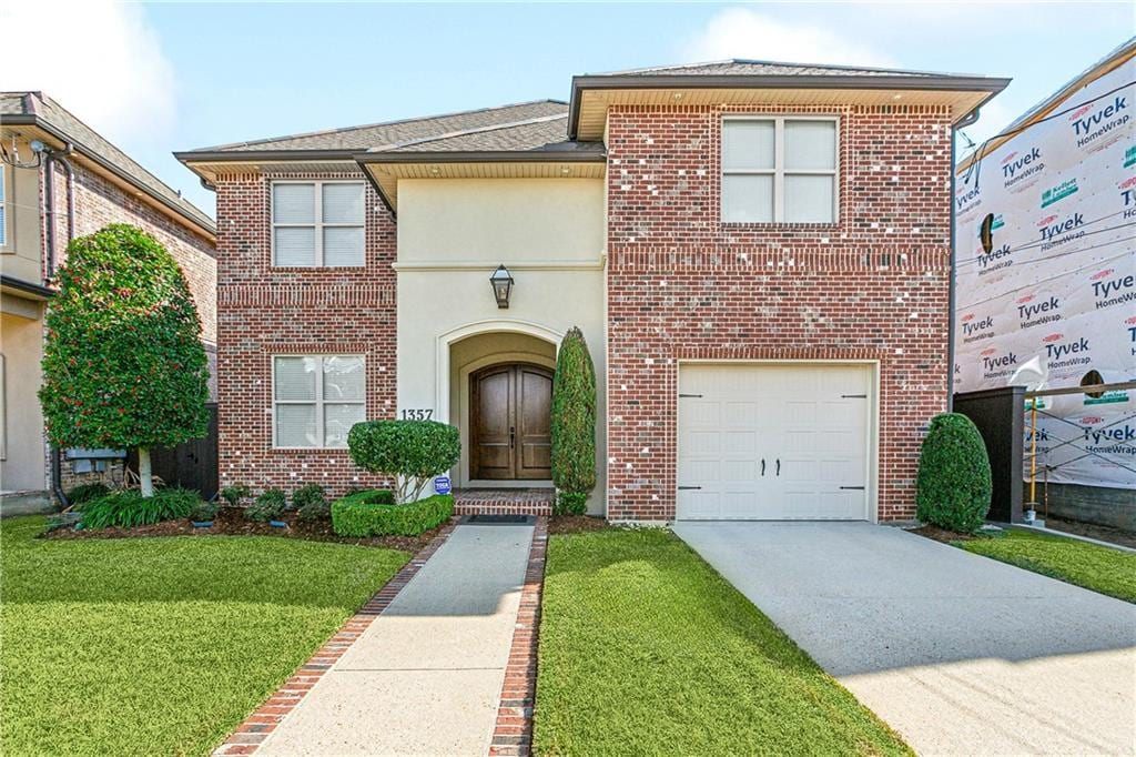 view of front of property featuring a garage and a front lawn