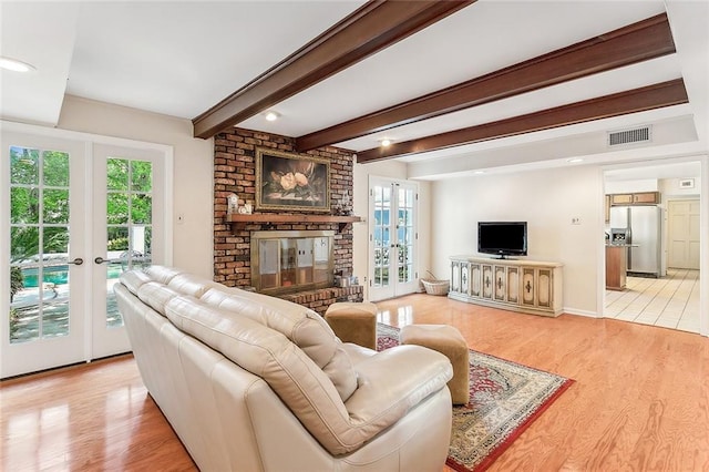 living room with a fireplace, wood-type flooring, french doors, and beamed ceiling