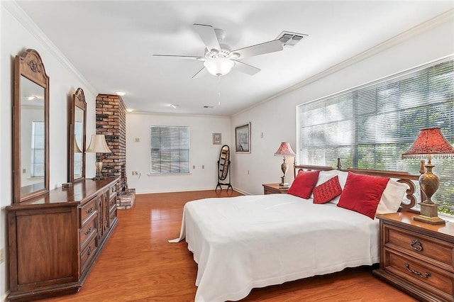 bedroom featuring ceiling fan, ornamental molding, and light hardwood / wood-style flooring