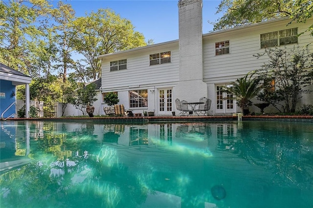 view of swimming pool featuring french doors