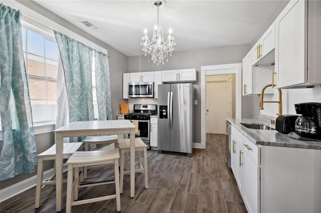 kitchen with sink, white cabinetry, appliances with stainless steel finishes, dark hardwood / wood-style floors, and backsplash