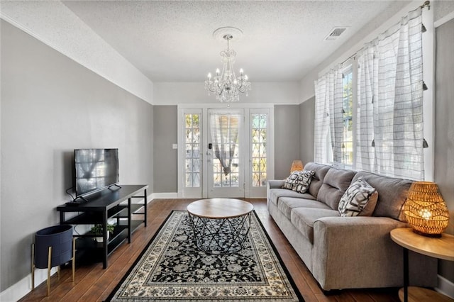 living room featuring plenty of natural light, dark hardwood / wood-style floors, and a textured ceiling