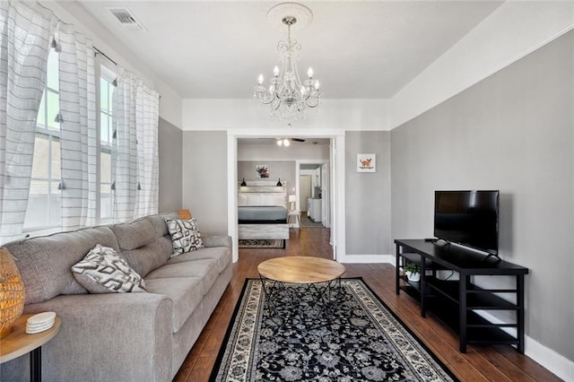 living room featuring dark wood-type flooring and an inviting chandelier