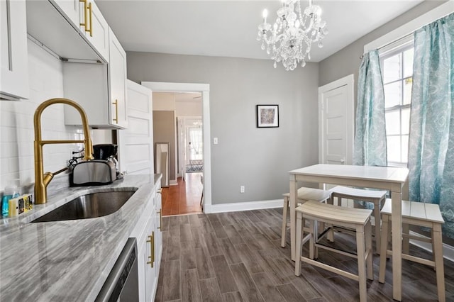 kitchen featuring light stone countertops, sink, and white cabinets